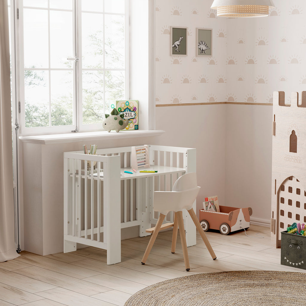 Mini-berço Converbaby 90x50 convertido em secretária infantil, com cadeira e materiais escolares.