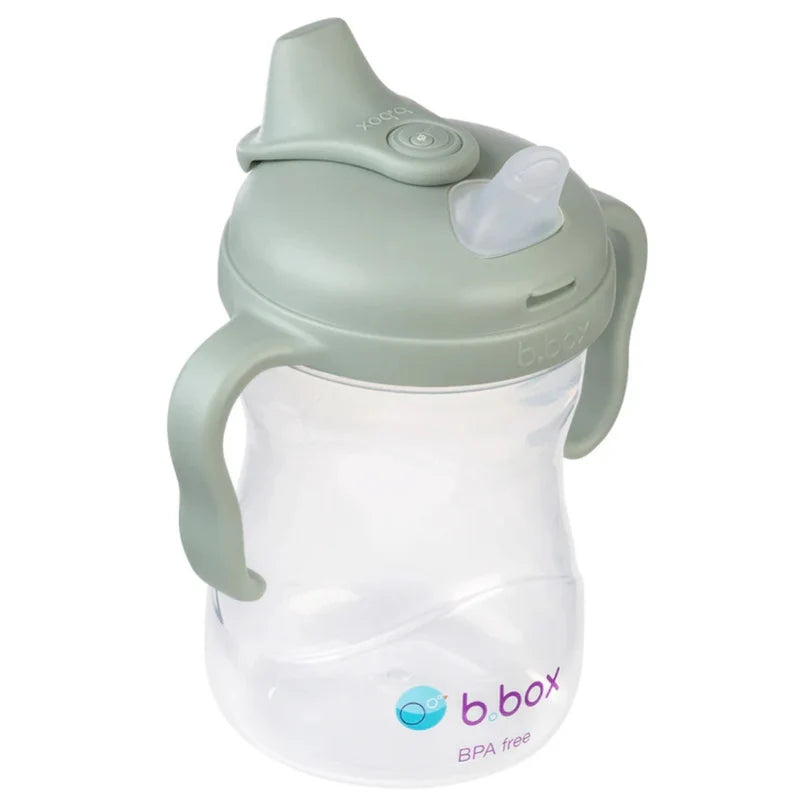 Vista lateral do copo de transição b.box, evidenciando o bico de silicone e a tampa protetora fechada.