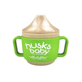 Copo de transição verde e bege da marca Husk's Baby, com pegas laterais e tampa, feito de fibra de arroz.