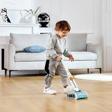 Criança a brincar com o aspirador robô Hape numa sala de estar.