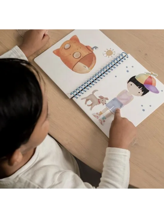 Criança a interagir com um livro de atividades Little Dutch aberto, colocando um autocolante no boneco, demonstrando o uso do produto.