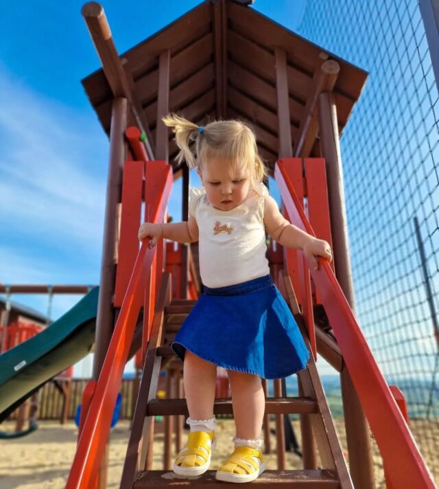 Criança a usar sandálias Boatilus Bioty amarelas a brincar no parque infantil.