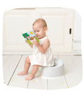 Fotografia real de uma criança sentada no Magic Potty a ler o livro incluído, mostrando o uso prático do produto.