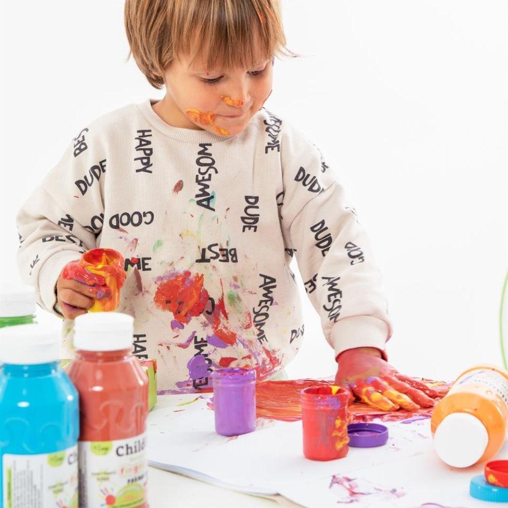 Criança a brincar e a pintar com as mãos, usando tintas coloridas, demonstrando o uso divertido da paleta ChildGen.