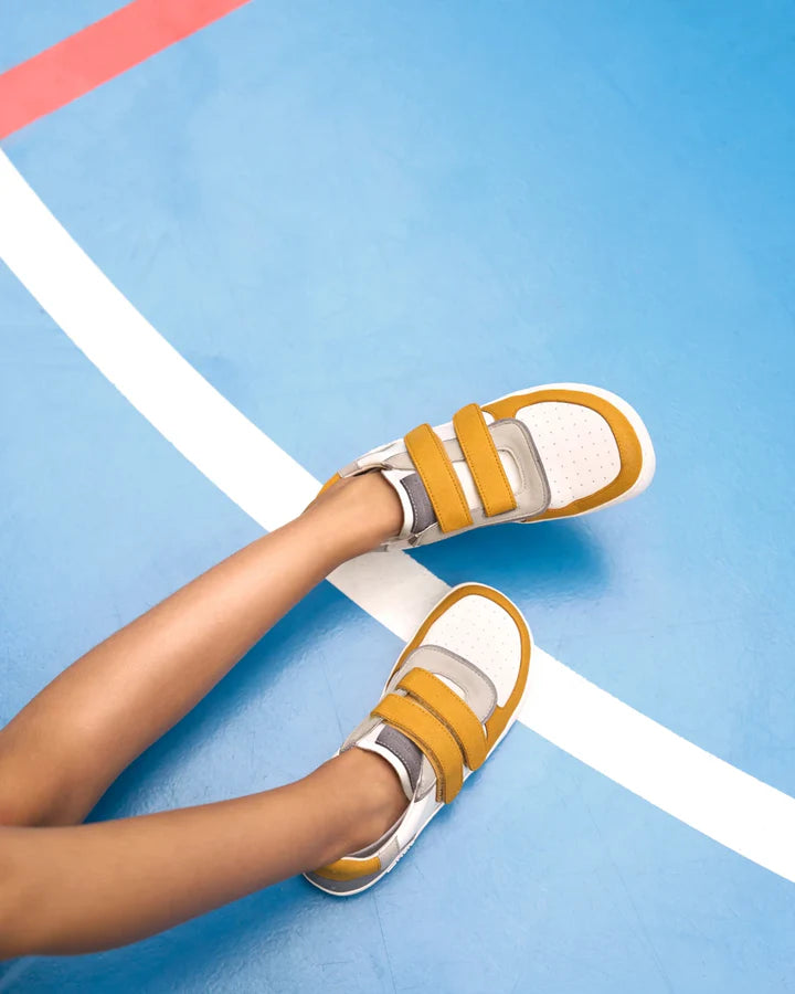 Sapato barefoot infantil Muris Barefoot Petra Junior Mustard, modelo branco com detalhes mostarda e fecho em velcro duplo. Sola flexível zero-drop para máximo conforto e liberdade de movimento.

