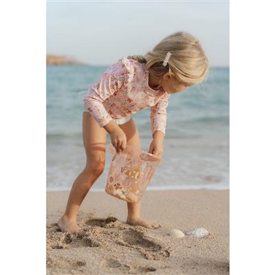 Criança pequena de fato de banho a recolher areia e conchas com o balde Sanko Ocean Dreams da Little Dutch na praia.