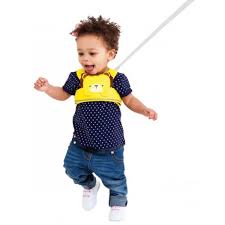 Criança pequena a sorrir enquanto usa o arnês de segurança Trunki ToddlePak com tema de leão.