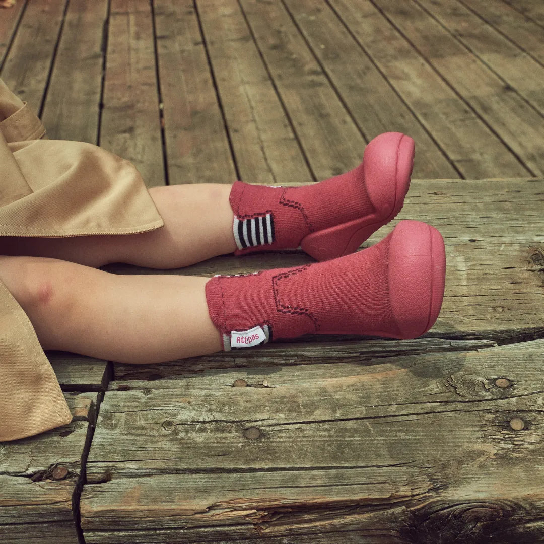 Grupo de crianças sentadas lado a lado, cada uma com uma cor diferente dos Attipas Rain Boots, evidenciando a coleção completa.