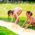Duas crianças brincando num jardim, divertindo-se num escorrega de água insuflável Leopard da Swim Essentials.