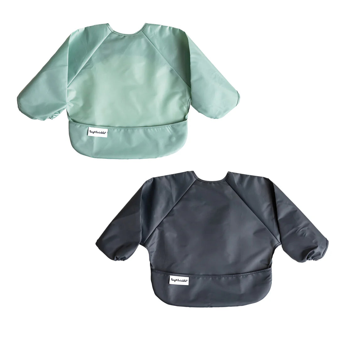 Conjunto de dois babetes Tiny Twinkle com mangas, um em tom verde menta e outro cinza escuro, apresentados individualmente em fundo branco.