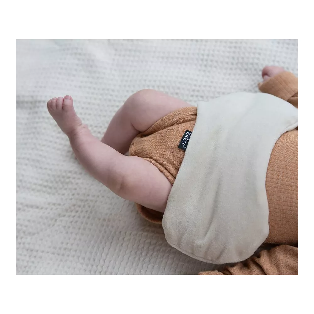 Detalhe da almofada térmica Woller bege sobre a barriga de um bebé