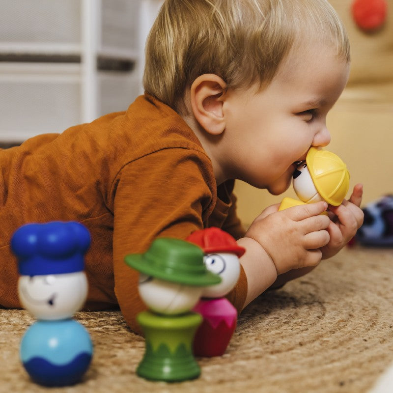 Close-up de uma criança brincando com as figuras, focando nos detalhes das expressões e cores vibrantes das peças.