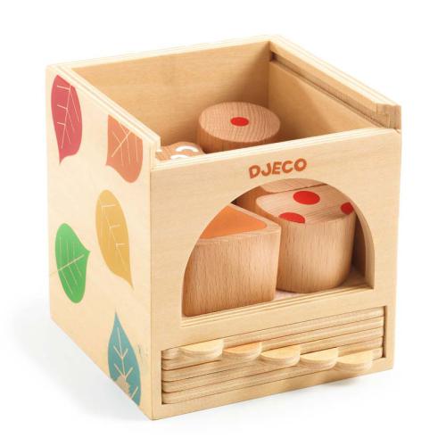 Cubo de atividades Djeco Basic Box em madeira com ilustrações de folhas, mostrando peças geométricas no interior.