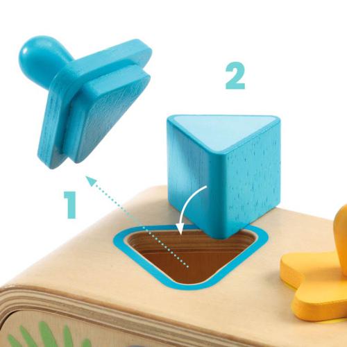 Detalhe de uma peça azul triangular do Djeco Jogo de Encaixe de formas e cores a ser inserida no orifício correspondente na caixa.
