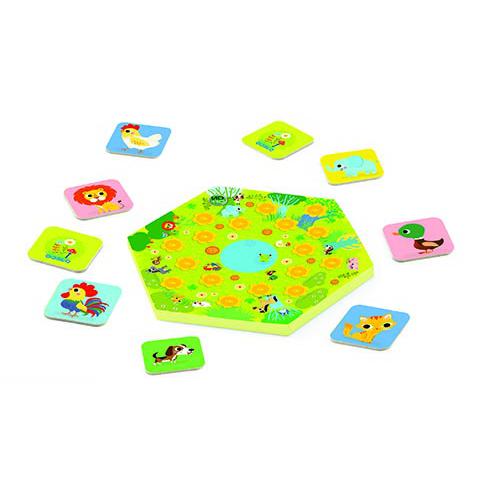 Componentes do jogo Djeco Memo Meuh espalhados: tabuleiro central hexagonal e cartas de animais.