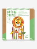 Kit Djeco "Pequeno Leão" para construir um apanhador de sonhos DIY, mostrando o suporte de cartão do leão e os materiais incluídos.