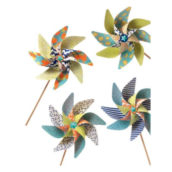Quatro moinhos de vento acabados, com padrões geométricos e florais em tons de verde, azul, laranja e amarelo, fotografados individualmente.