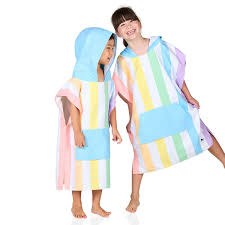 Duas crianças sorridentes vestem ponchos de praia Dock and Bay com riscas verticais pastel, ideal para 6-10 anos.