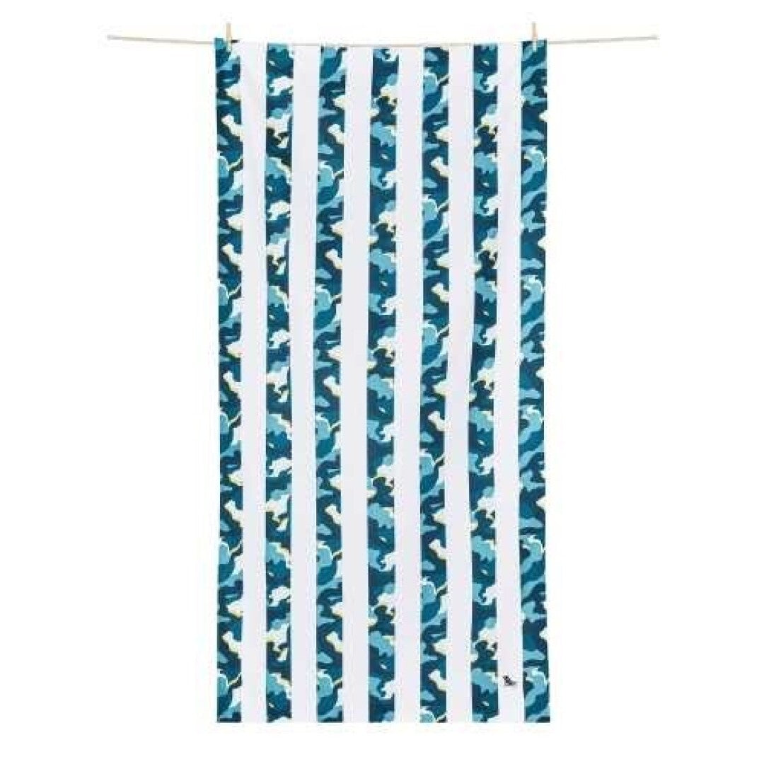 Toalha de praia Dock and Bay de secagem rápida com riscas azuis e brancas alternadas com padrão camuflado azul, pendurada num varal.