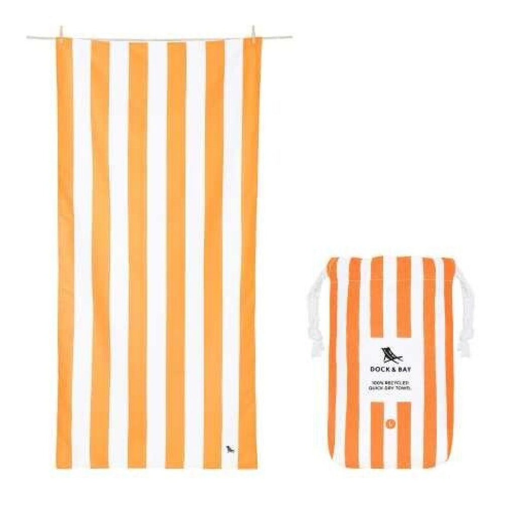 Toalha de praia Dock and Bay listrada laranja e branca estendida, ao lado da sua bolsa de transporte compacta com padrão listrado correspondente.