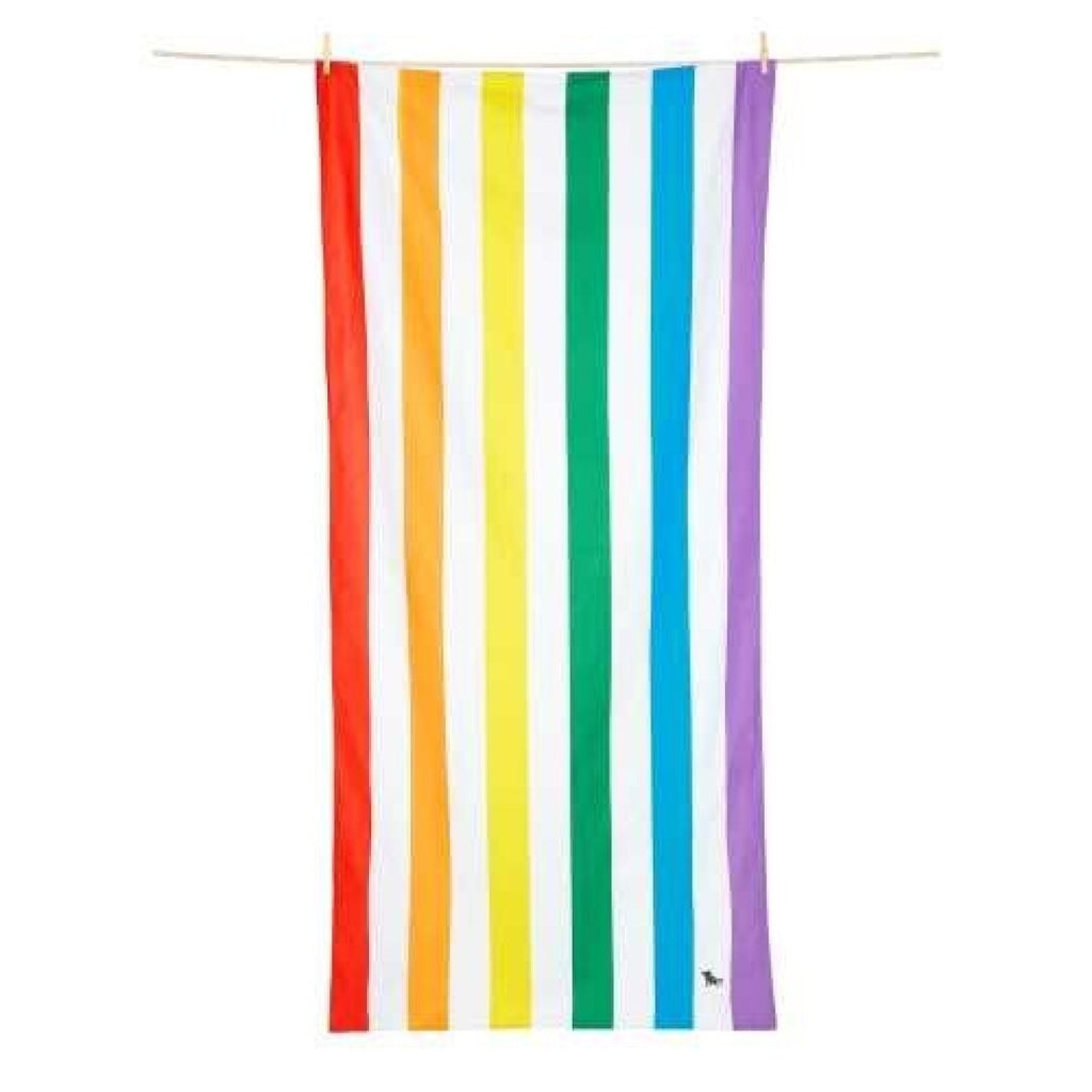 Toalha de praia Dock and Bay de secagem rápida com riscas verticais vibrantes de arco-íris (vermelho, laranja, amarelo, verde, azul, lilás) suspensa num varal.
