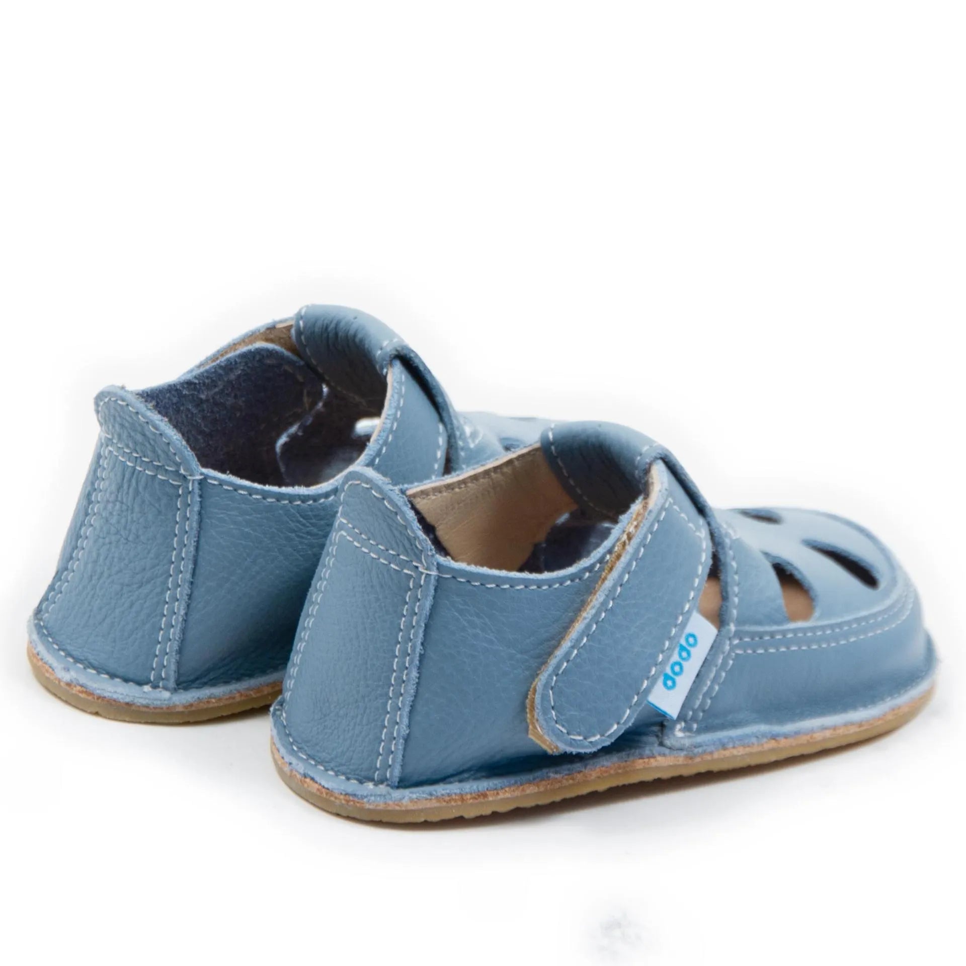 Vista lateral das sandálias barefoot Dodo Shoes em azul claro, com sistema de fecho em Velcro para um ajuste seguro e design anatómico para um desenvolvimento saudável dos pés.