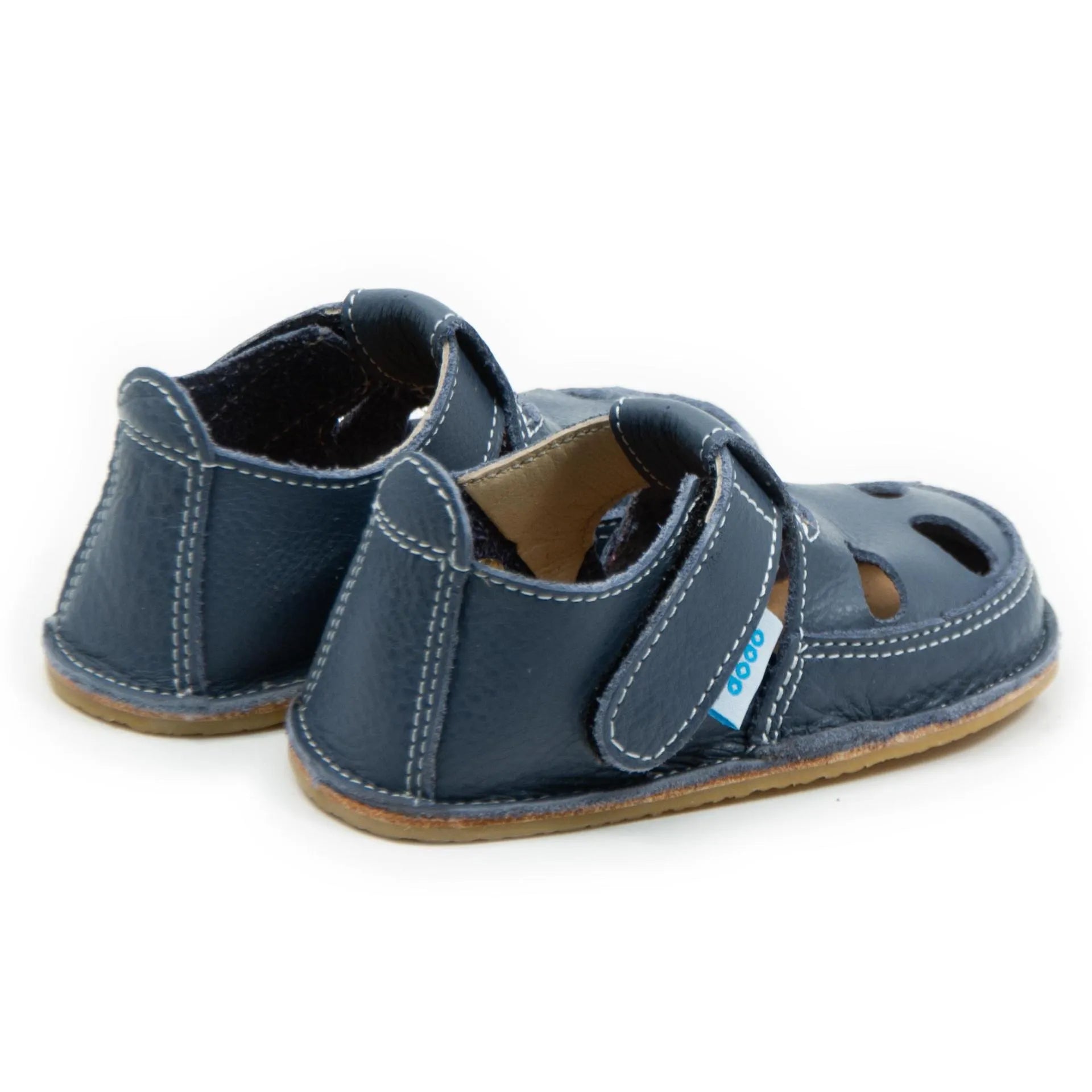 Vista lateral das sandálias barefoot Dodo Shoes em azul escuro, com sistema de fecho em Velcro para um ajuste seguro e design anatómico para apoiar o desenvolvimento saudável dos pés.