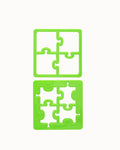 Dois cortadores de plástico verde brilhante em formato de puzzle, um maior e um menor, sobre fundo branco.