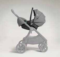 Cadeira auto cinza para bebé com inclinação ajustável instalada em base ISOFIX, mostrando a reclinação lateral.