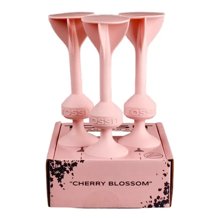 Três dardos TOSSIT cor-de-rosa "Cherry Blossom" pousados sobre a sua caixa de edição limitada.
