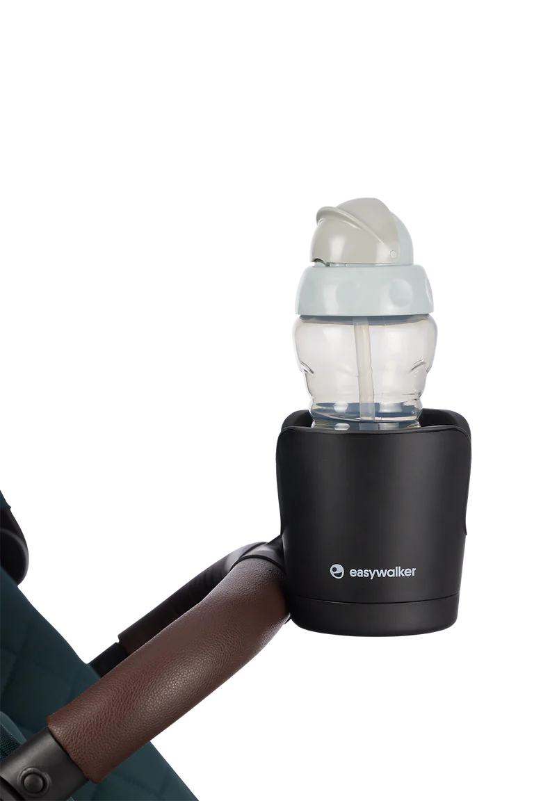 Suporte para copos preto Easywalker com biberão de criança inserido, fixado ao guiador de um carrinho de passeio com acabamento em pele castanha.