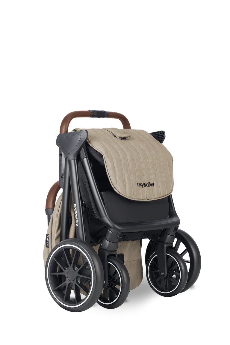 Carrinho Easywalker Jackey² XL bege, dobrado em posição compacta, pronto para transporte, destacando as rodas grandes.