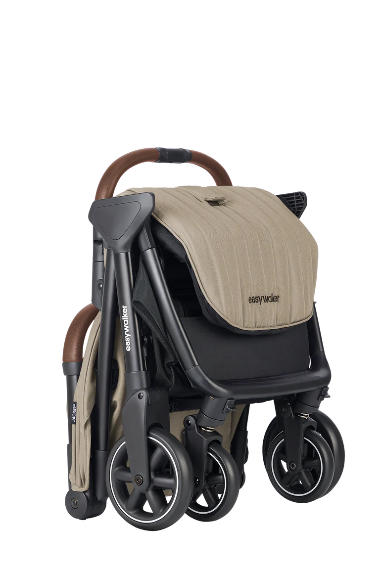 Carrinho Easywalker Jackey² bege dobrado, compacto e autónomo, pronto para transporte ou arrumação.