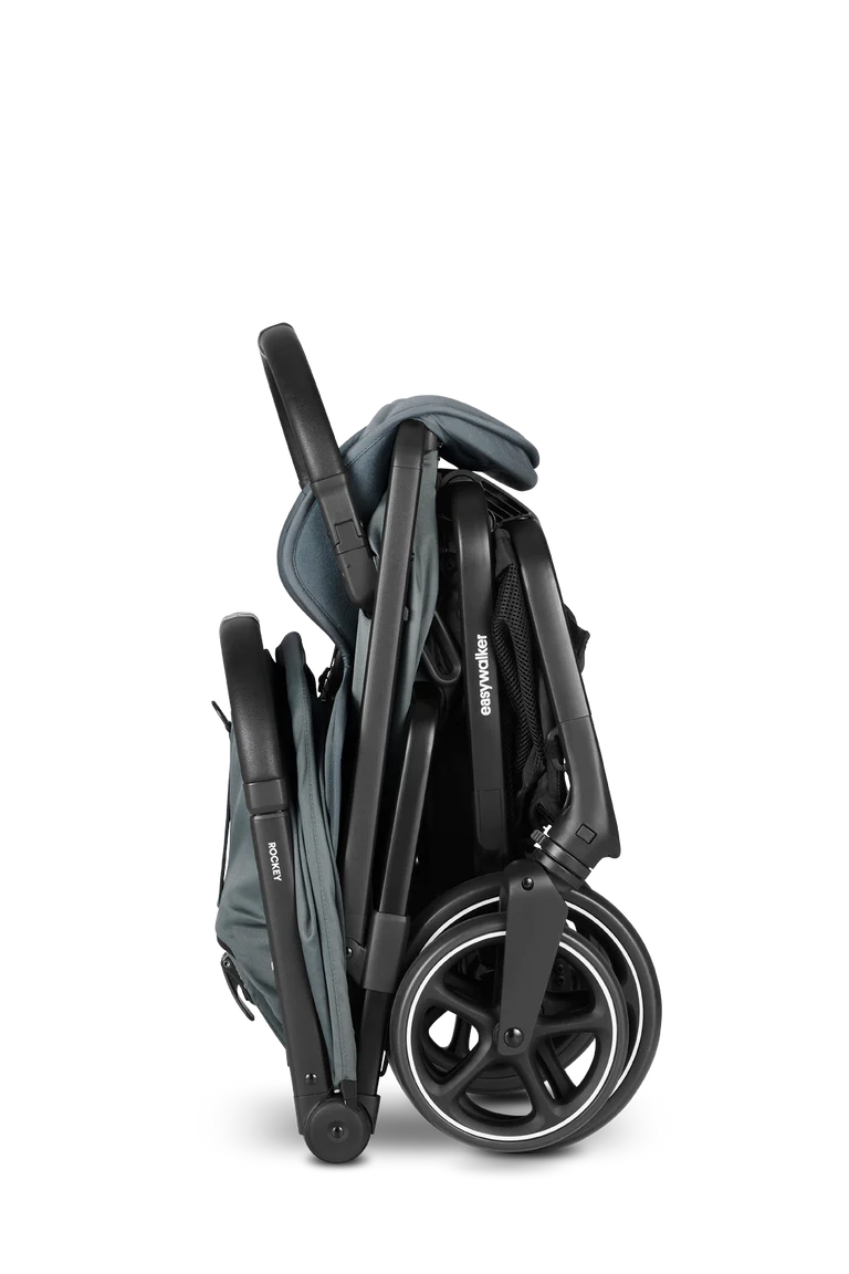 Easywalker Rockey L dobrado, mostrando o mecanismo compacto de fecho e as rodas grandes, ideal para arrumação fácil.