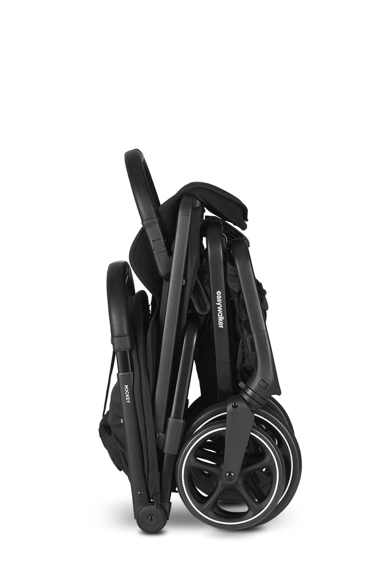 Carrinho de passeio Easywalker Rockey L preto dobrado, compacto para arrumação fácil, com rodas visíveis.