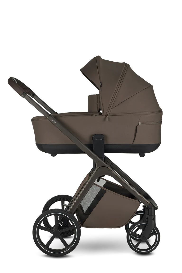 Carrinho Easywalker Zoey com a alcofa acoplada, visto de perfil, destacando o design moderno e a suspensão das rodas. Cor castanha escura.