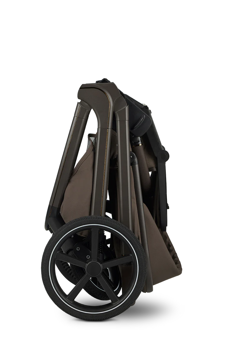 Detalhe do carrinho Easywalker Zoey dobrado, mostrando o mecanismo compacto e as rodas grandes, ideal para transporte e arrumação. Fundo preto.