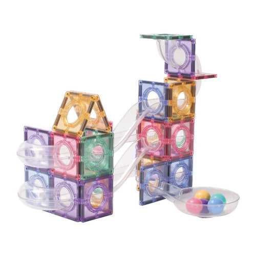 Exemplo de construção de pista de bolas com blocos magnéticos, mostrando as rampas transparentes a levar as bolas para uma taça na base.
