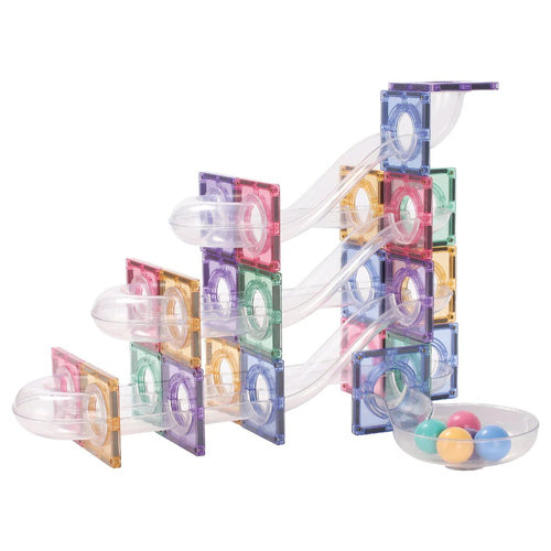 Vista lateral detalhada de uma complexa pista de bolas construída com blocos magnéticos transparentes em tons pastel, com várias descidas e uma taça final.