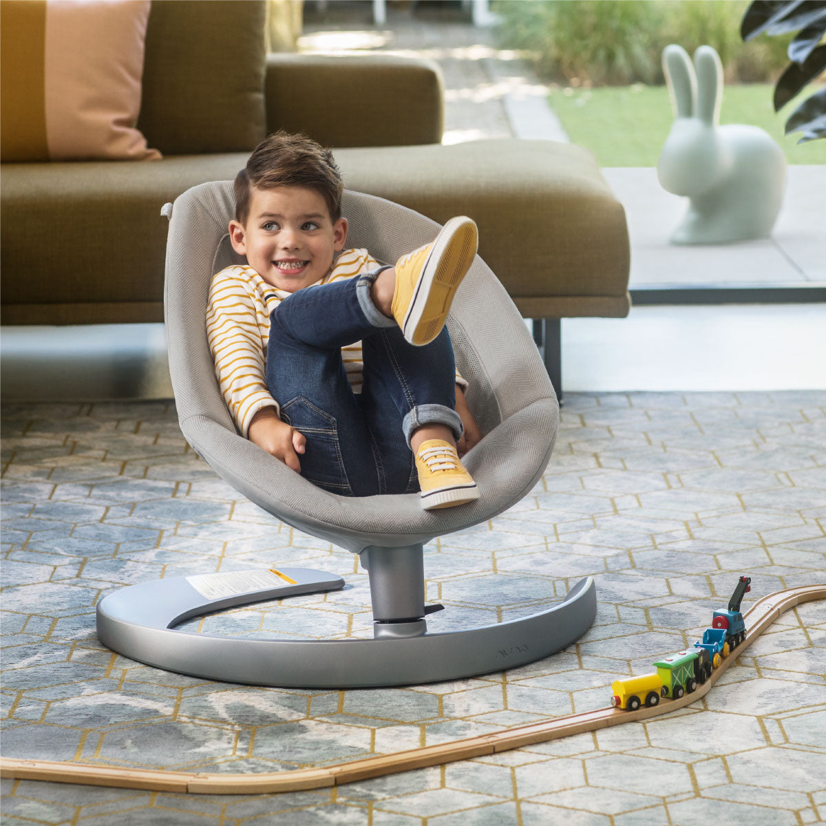 Espreguiçadeira Nuna Leaf Grow com arco de jogos incluído, mostrando brinquedos pendurados sobre o assento.
