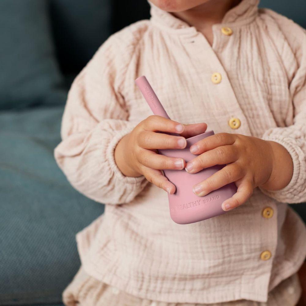 Os dois copos de silicone (azul e rosa) dentro de uma máquina de lavar louça, mostrando que são fáceis de limpar e aptos para máquina.