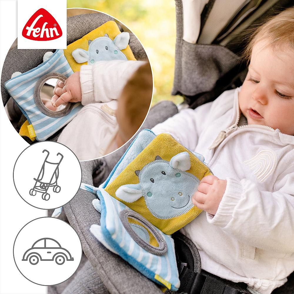 Bebé a interagir com o livro sensorial Fehn preso ao carrinho de passeio. Inserções mostram o livro em uso no carrinho e no carro.