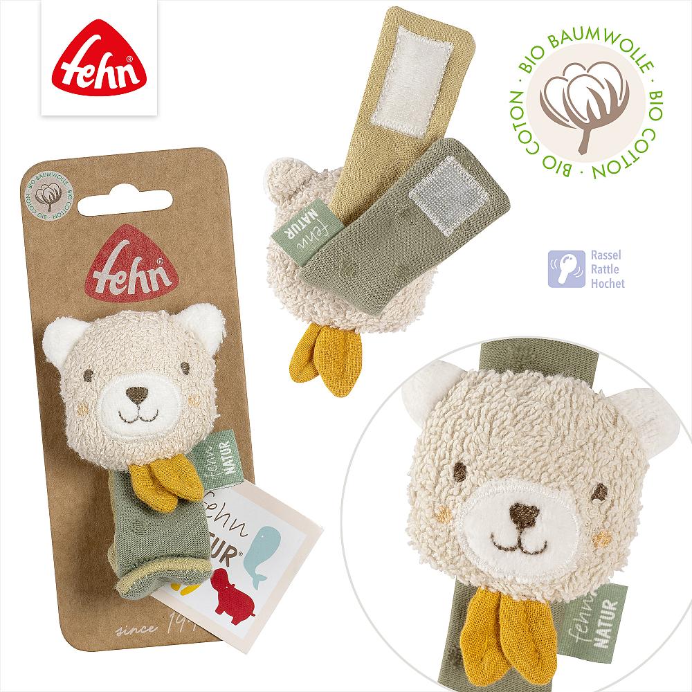 Conjunto de imagens da pulseira Fehn Urso com guizo, mostrando a embalagem de cartão, o fecho de velcro e os materiais de algodão orgânico.