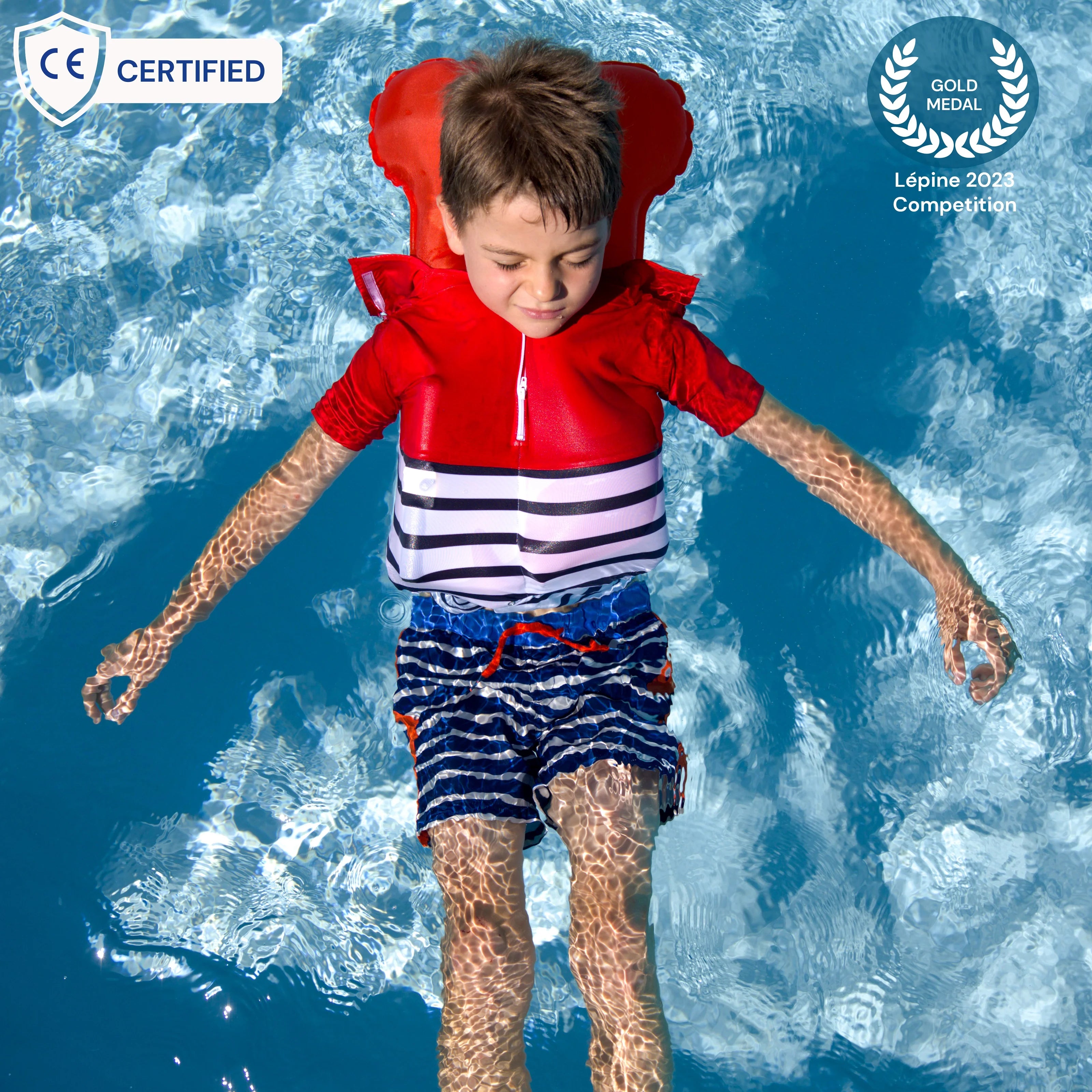 Criança flutua de costas na água com a T-shirt Floatee vermelha e branca inflada, com selos CE e Medalha de Ouro Lépiné 2023.