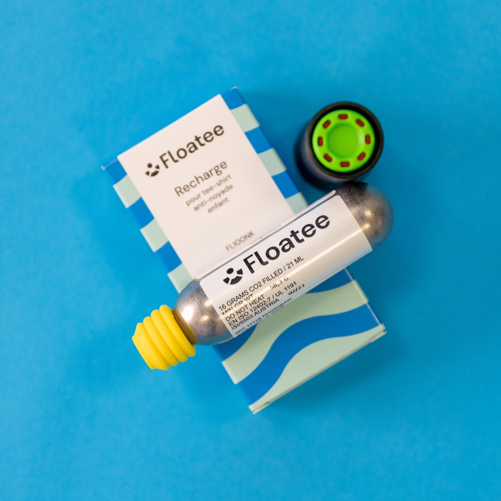 Cartucho de recarga de CO2 para a T-shirt Floatee, com embalagem de recarga, sobre fundo azul.
