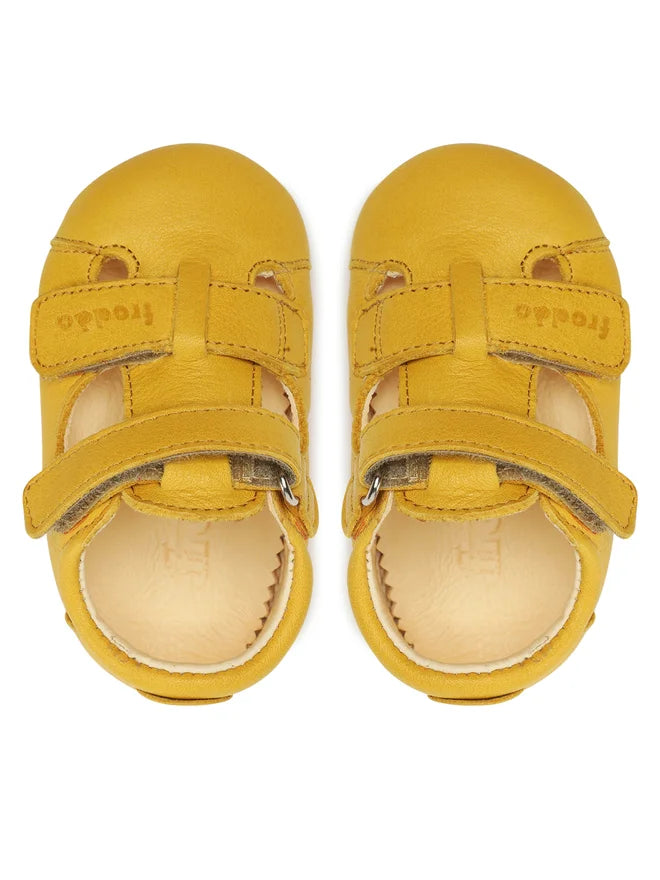 Vista superior da Froddo Barefoot Prewalkers sandália em couro amarelo, mostrando o design anatómico e a abertura que permite respirabilidade ao pé.