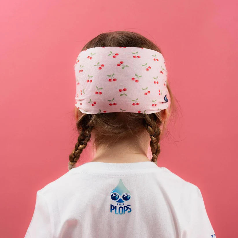 Vista traseira da cabeça de uma menina a usar os óculos Waterplops Cerejas, destacando o padrão de cerejas na banda elástica e o logótipo Waterplops na t-shirt.