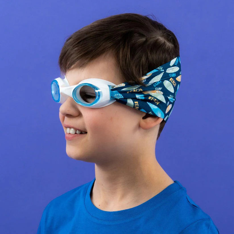 Criança a usar os Waterplops Óculos para Piscina Surf, vista lateral, mostrando a banda elástica de padrão de pranchas de surf.