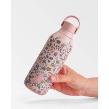 Mão a segurar a garrafa térmica Chilly's Kazusa 500ml, destacando o design floral e a pega da tampa.