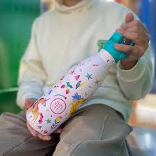 Criança ou jovem a segurar a garrafa térmica Cool Bottles Funny Unicorns 350ml com a tampa de palhinha aberta, em uso.